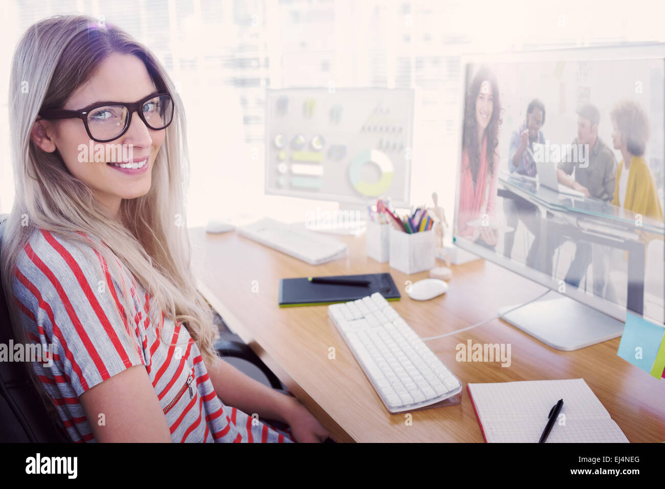Immagine composita di sorridere designer utilizzando tablet Foto Stock
