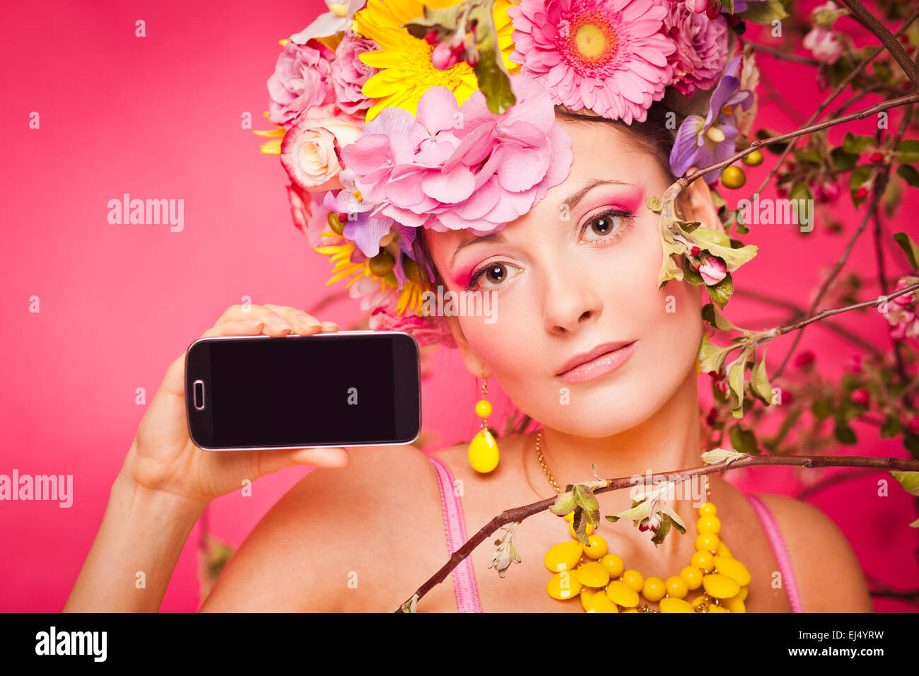 Ragazza sotto fiori di primavera con lo smartphone mockup Foto Stock