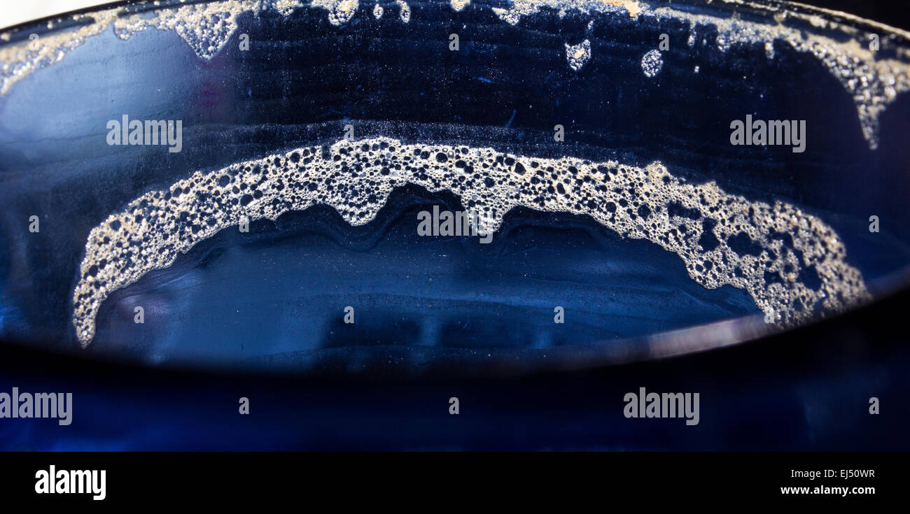 La parte superiore di un vuoto che la tazza da caffè con residuo schiumoso intorno al bordo dopo aver bevuto un cappuccino. Foto Stock