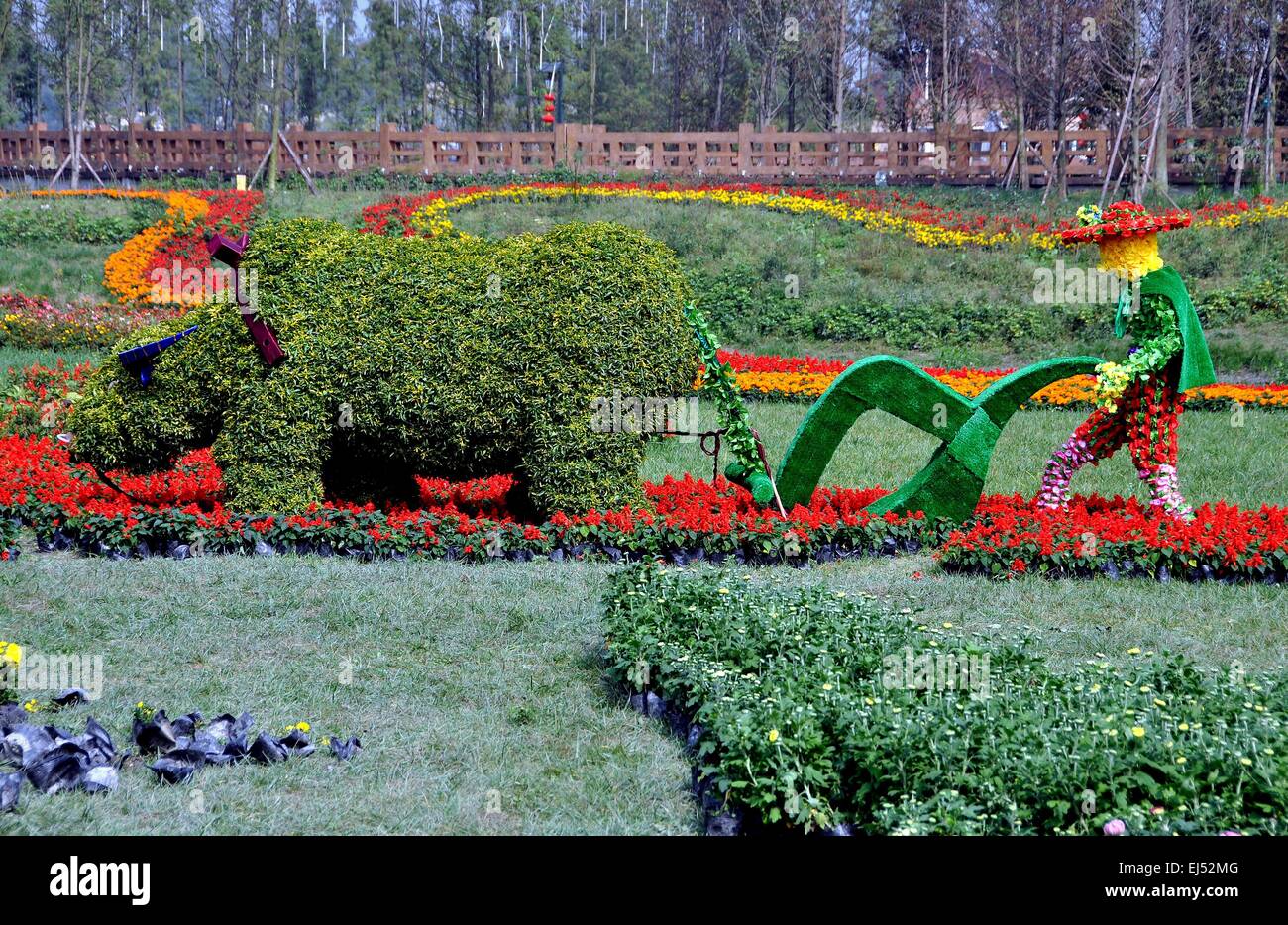 Qingbaijiang, Cina: Topiaria da contadino con bestia da soma arando un campo a Phoenix il Parco del Lago Foto Stock