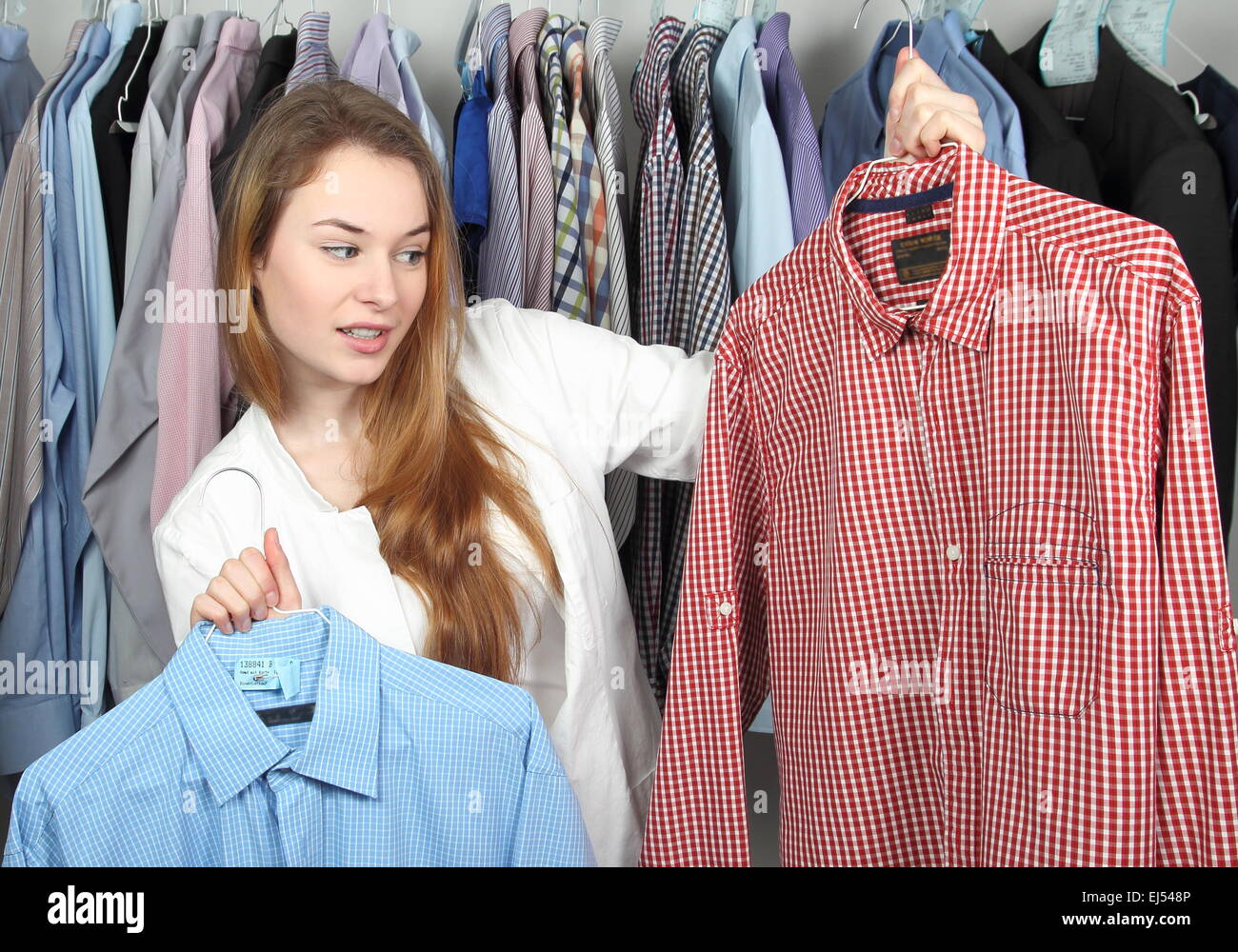 Una donna nel lavaggio a secco con due magliette sporche Foto Stock