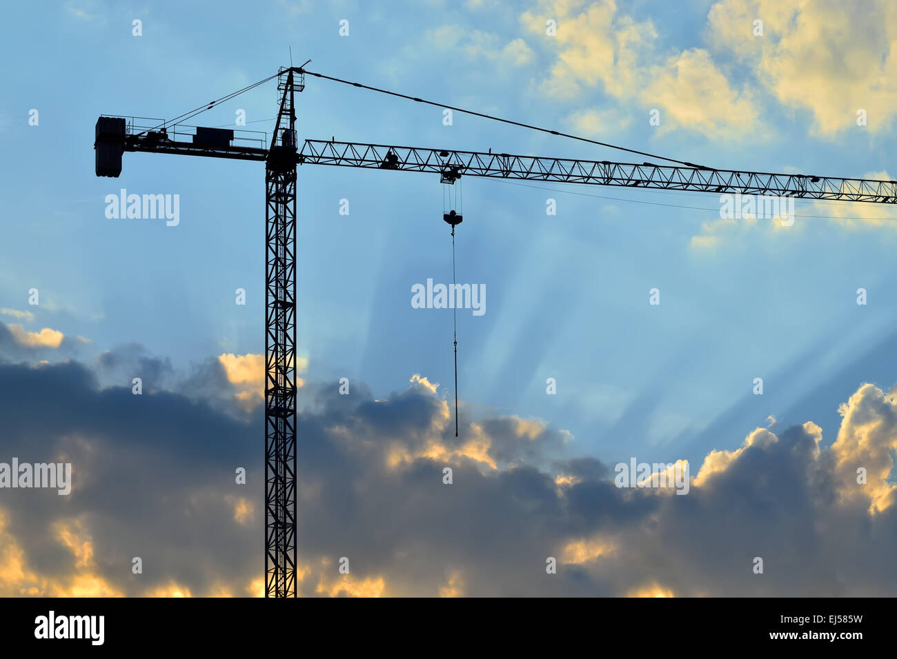 Silhouette di gru da cantiere e i raggi del sole Foto Stock