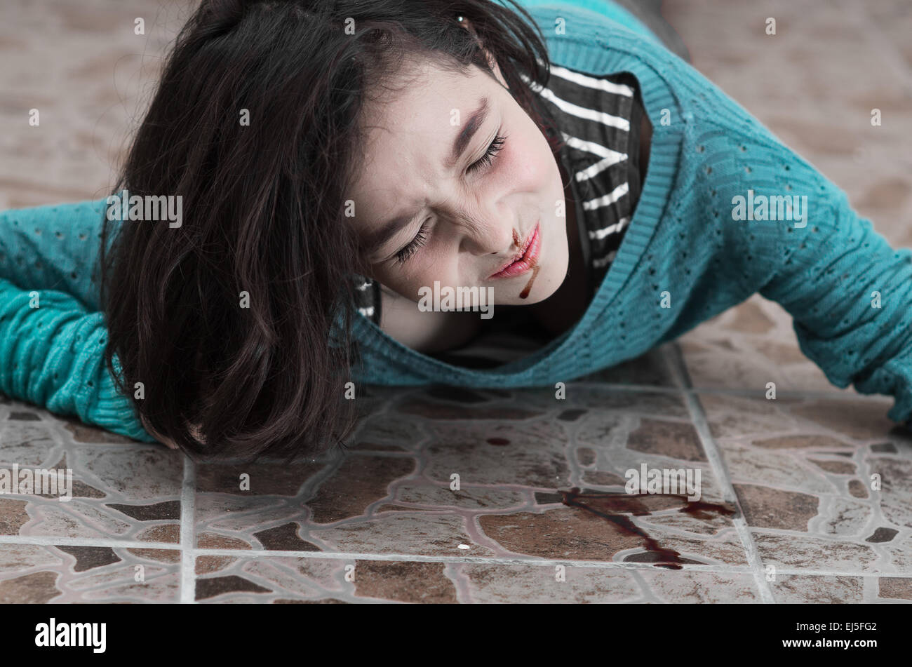 Ragazza giovane e carina con un sanguinamento del naso dopo la caduta verso il basso Foto Stock