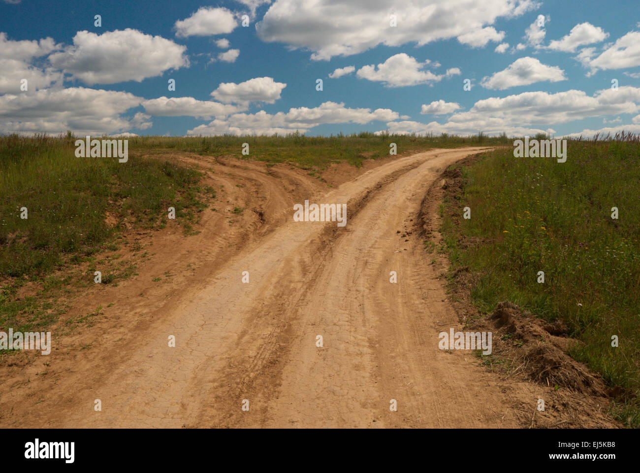 Una strada di campagna si divide in due strade Foto Stock