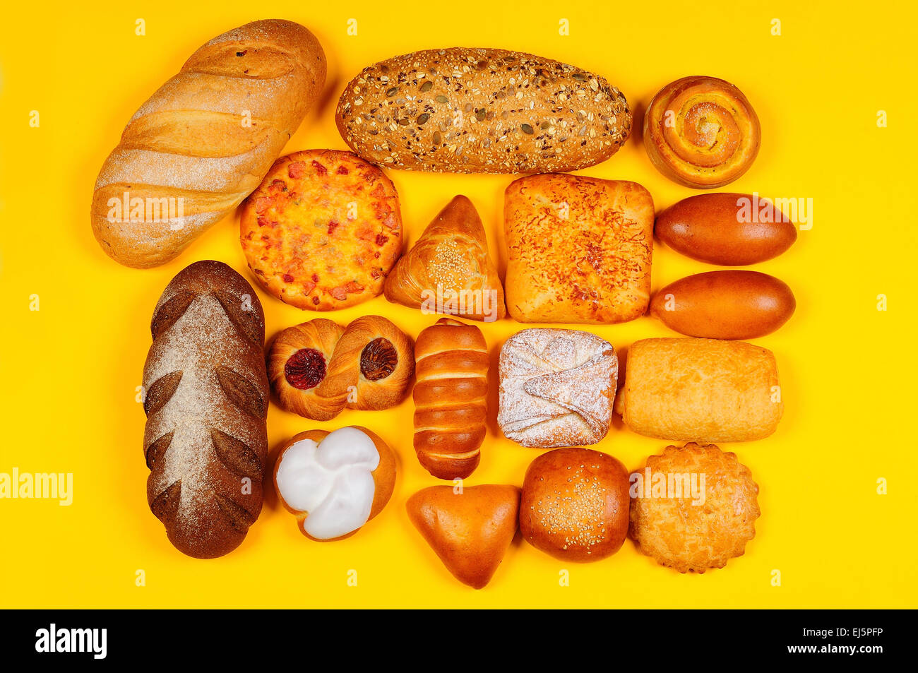 Assortimento di pane e pasticceria composto su sfondo giallo Foto Stock