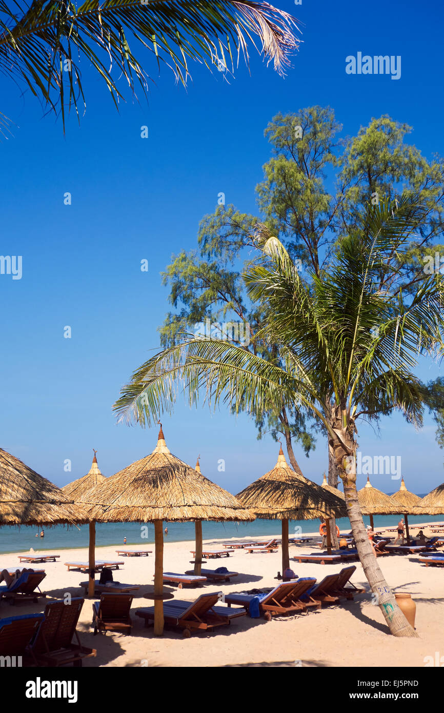 Palm Tree e ombrelloni di paglia con sedie a sdraio sulla spiaggia a Vinpearl Resort. Phu Quoc island, Kien Giang Provincia, Vietnam. Foto Stock