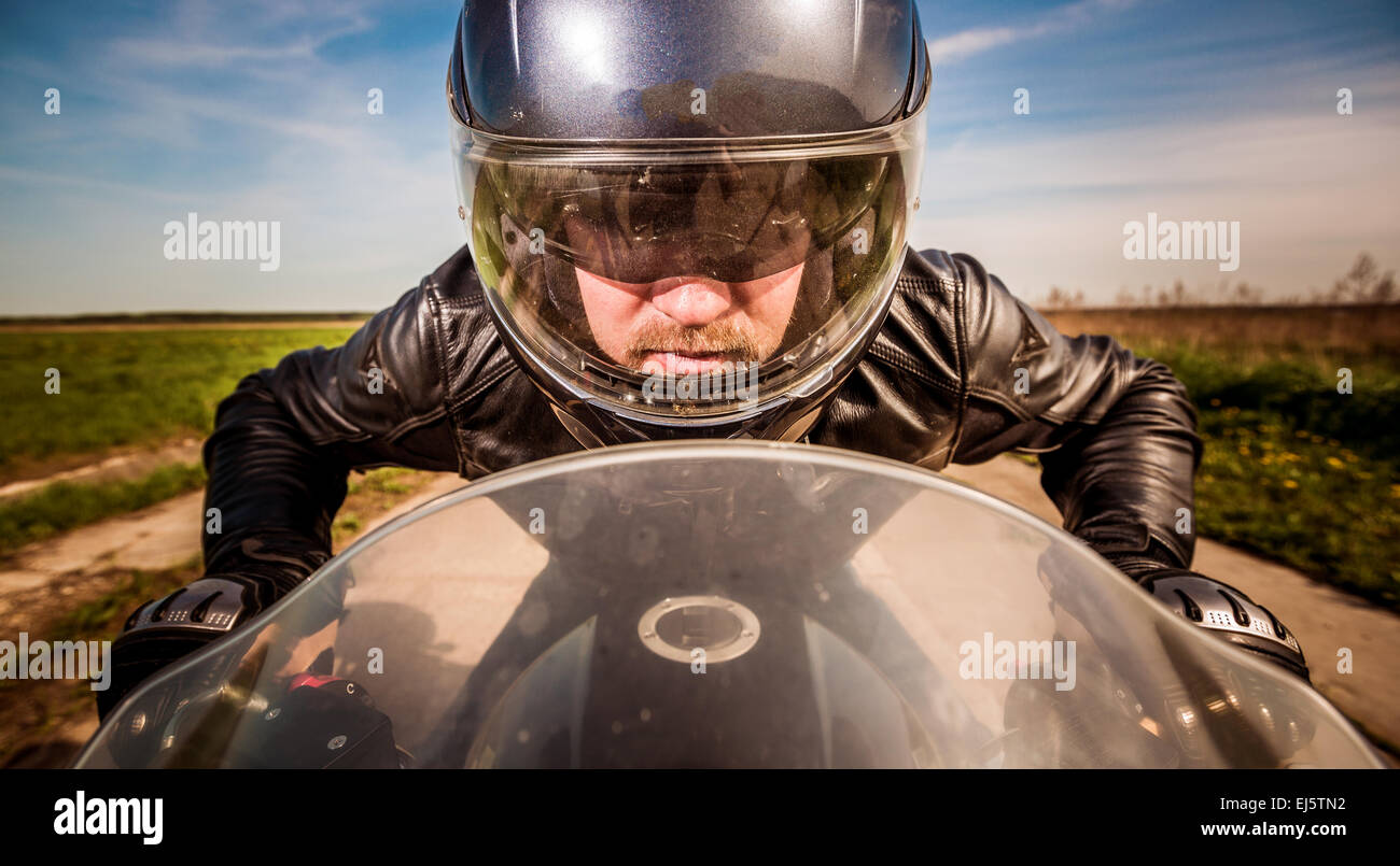 Biker in casco e giacca di pelle racing su strada Foto Stock Biker in casco e giacca di pelle racing su strada Foto Stock