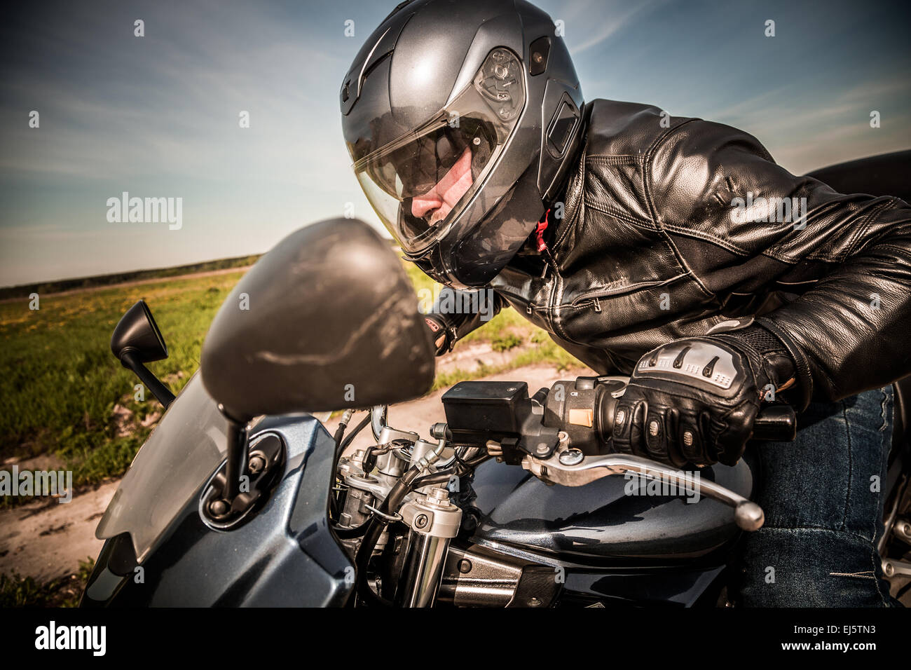 Biker in casco e giacca di pelle racing su strada Foto Stock Biker in casco e giacca di pelle racing su strada Foto Stock