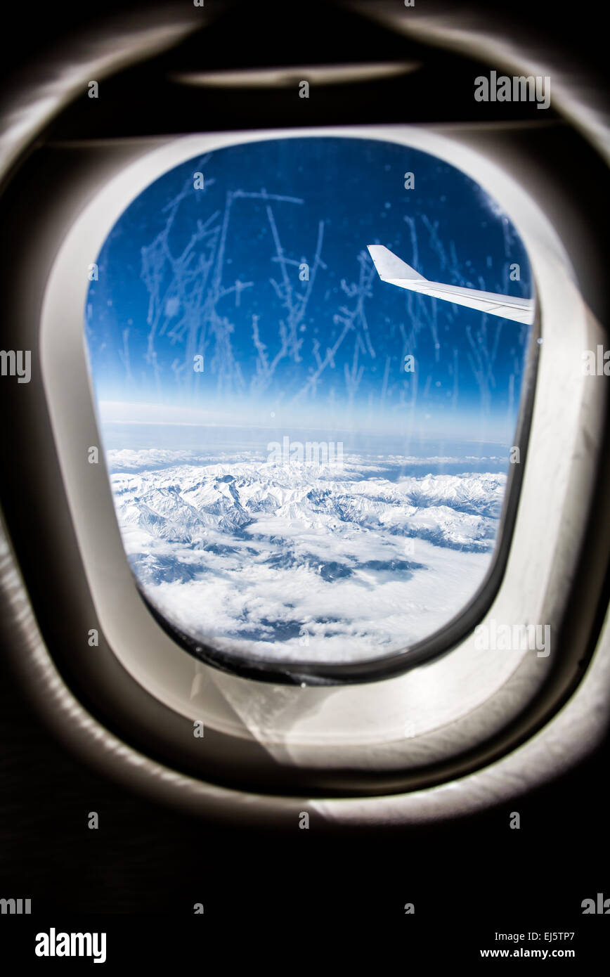 Immagine classica attraverso il finestrino per aerei sul motore jet. La brina sul vetro della finestra. Focus sull'ala del velivolo. Foto Stock