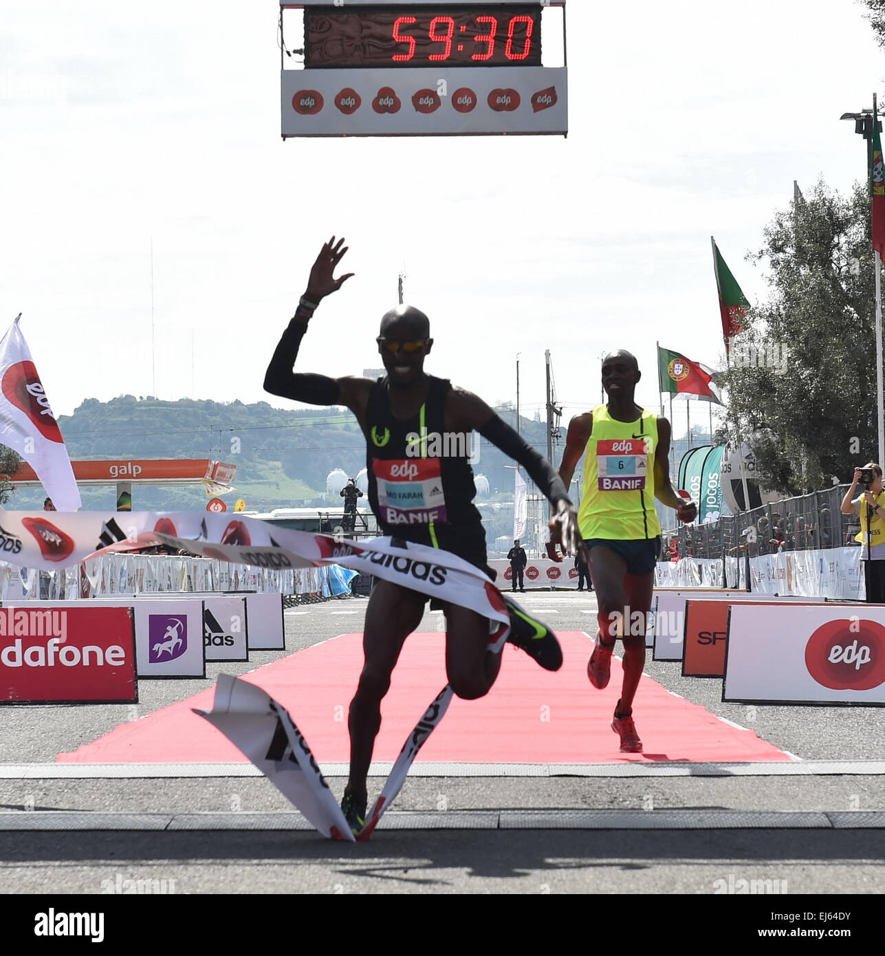 Lisbona. 22 Mar, 2015. Mo Farah (L) della Gran Bretagna cade dopo aver tagliato il traguardo del venticinquesimo Mezza Maratona di Lisbona gara a Lisbona, Portogallo, il Mar 22, 2015. Mo Farah ha preso il primo posto con un nuovo Parlamento a tempo di record. © Zhang Liyun/Xinhua/Alamy Live News Foto Stock