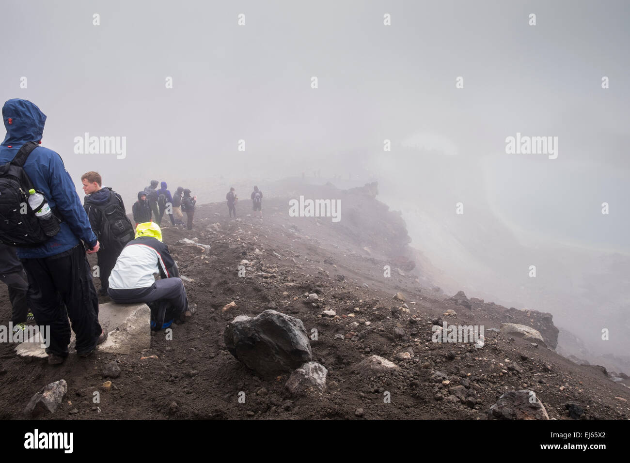 Walkers sul Tongariro alpine crossing sosta presso il lago blu in condizioni climatiche estreme, Nuova Zelanda. Foto Stock