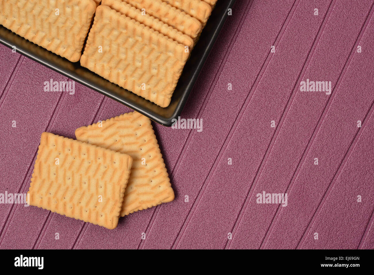 I cookie disposti in un nero vaso in ceramica con sfondo viola Foto Stock