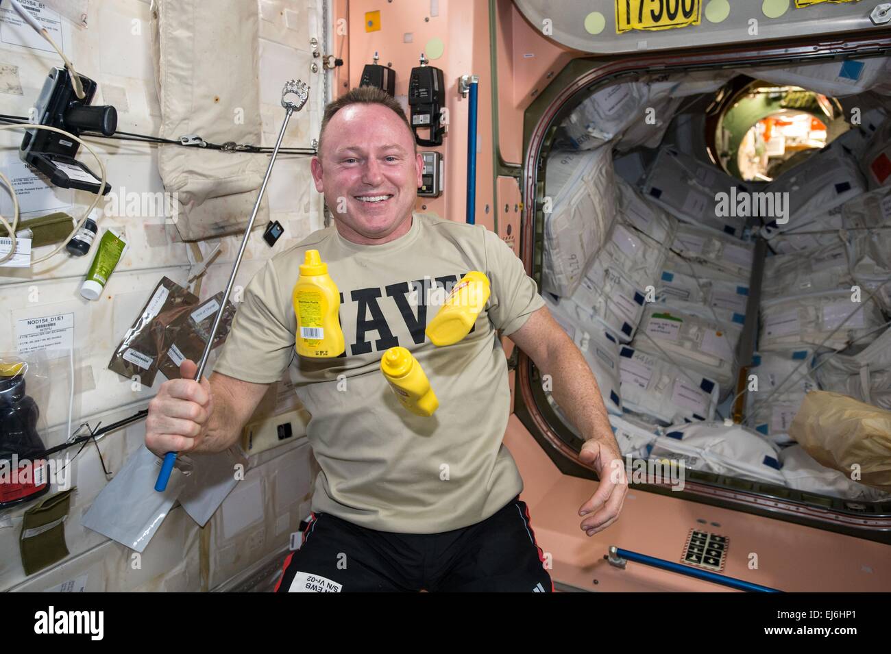 Astronauta statunitense Barry Wilmore giocola bottiglie di senape in microgravità mentre si prepara a prendere un esperimento in lettura il micro5 dragon pink laboratorio Columbus Gennaio 20, 2015 in orbita intorno alla terra. Foto Stock Astronauta statunitense Barry Wilmore giocola bottiglie di senape in microgravità mentre si prepara a prendere un esperimento in lettura il micro5 dragon pink laboratorio Columbus Gennaio 20, 2015 in orbita intorno alla terra. Foto Stock