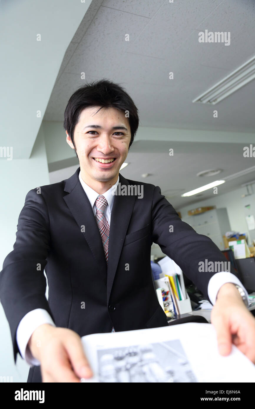Un giovane giapponese freshman lavora in ufficio Foto Stock