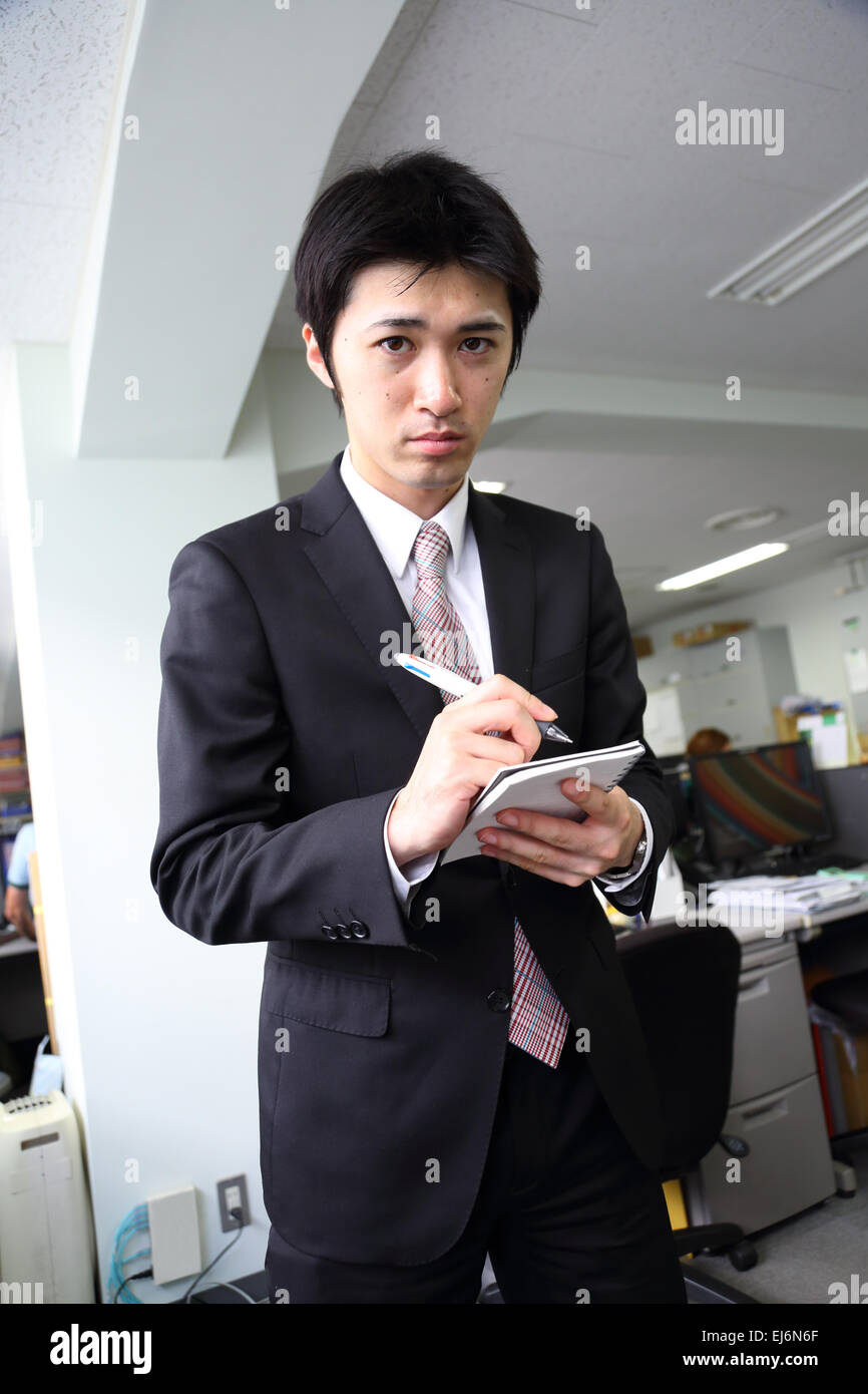 Un giovane giapponese freshman lavora in ufficio Foto Stock