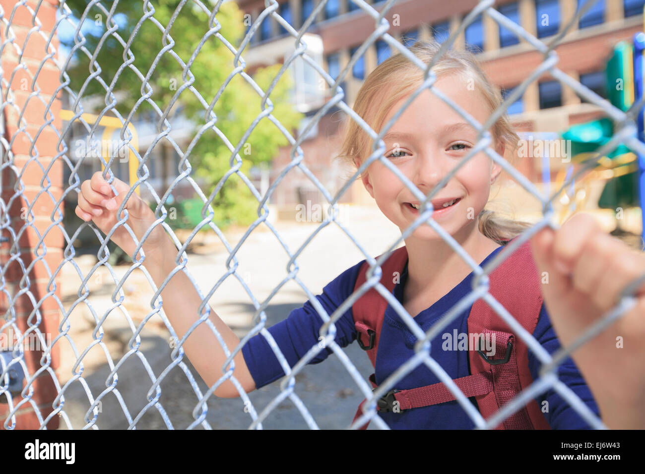 Un sorridente bambina a scuola parco giochi Foto Stock