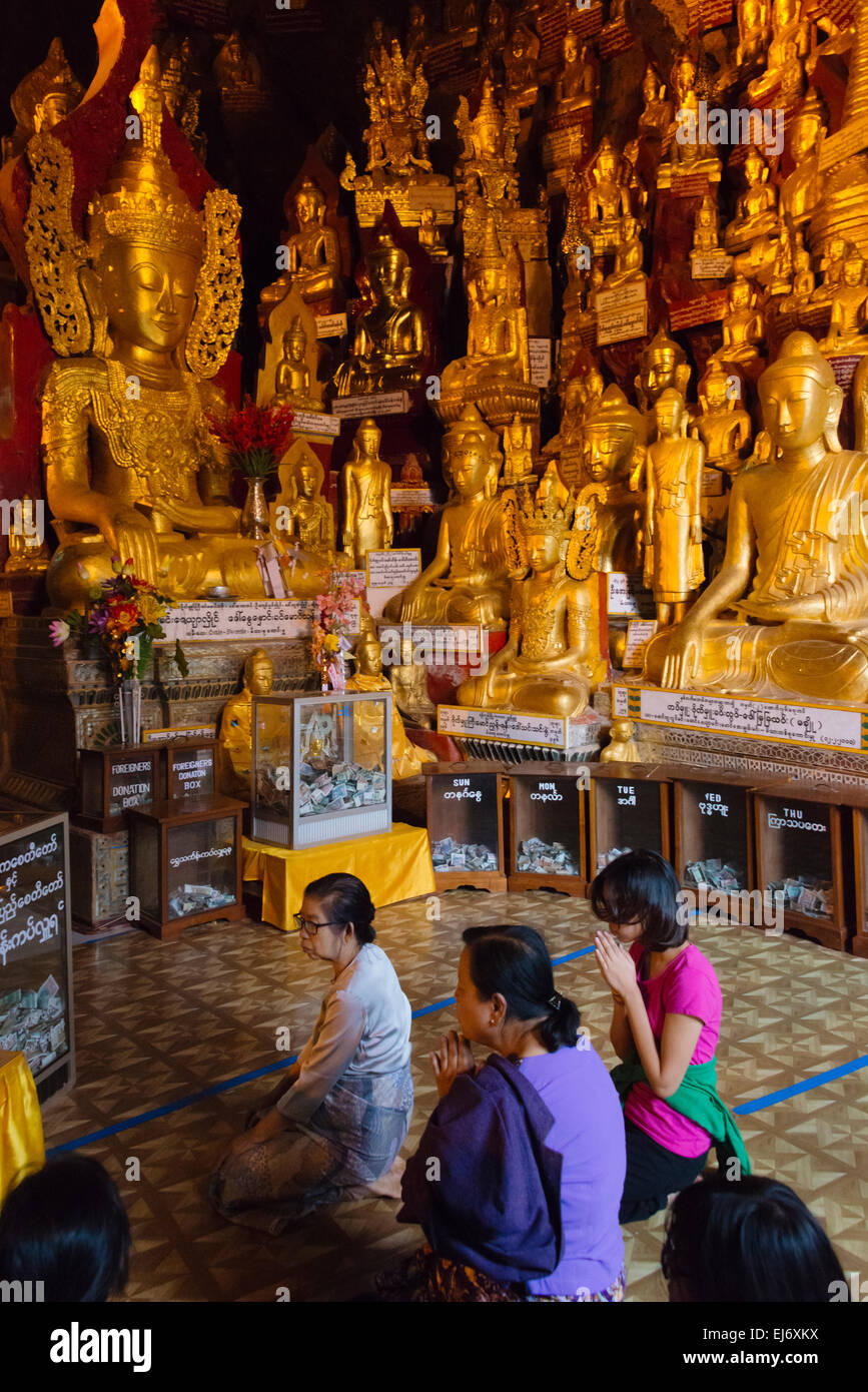 Pellegrini in preghiera di fronte statue buddiste all'interno della grotta di Pindaya, Stato Shan, Myanmar Foto Stock