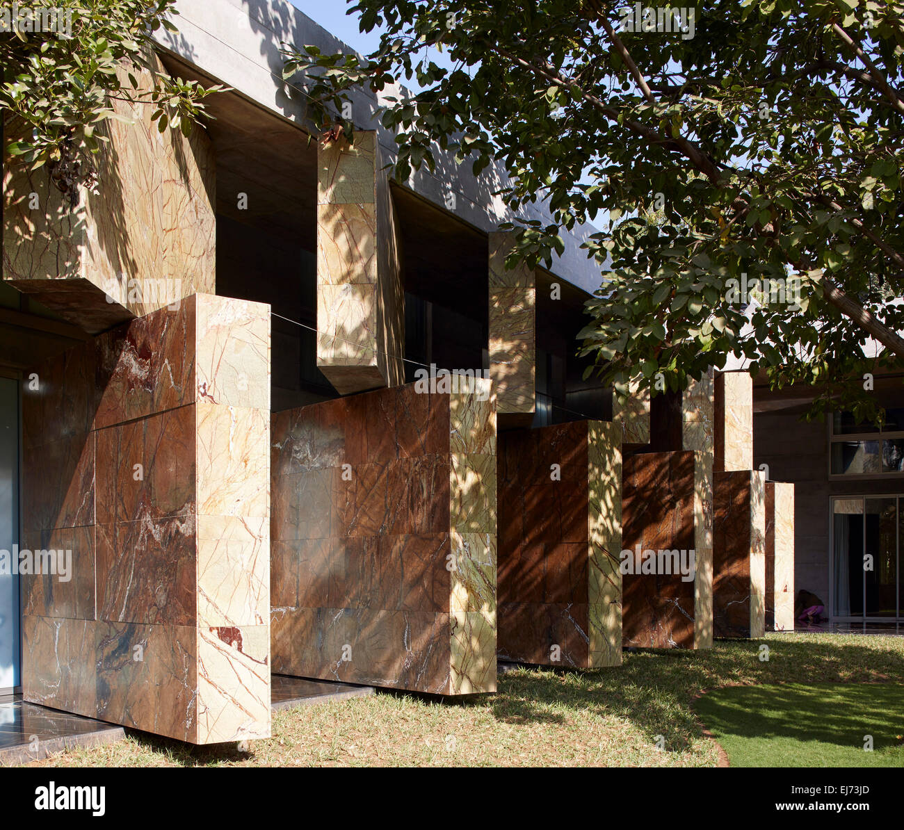 Vista complessiva da giardino con pareti in posizione aperta. Casa con pareti, Ahmedabad, India. Architetto: Matharoo Associates, 2015. Foto Stock