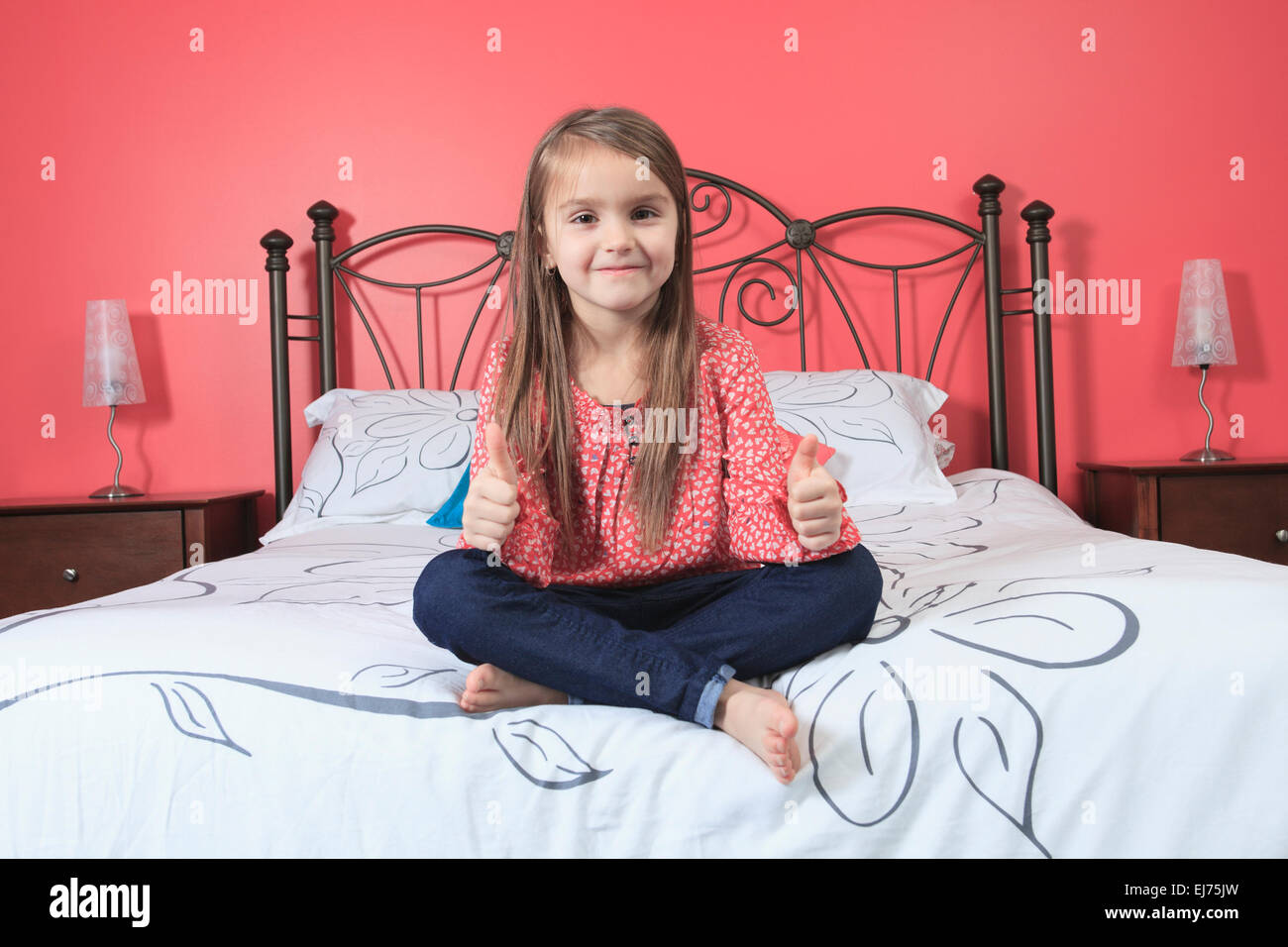 Bellissima bambina sedersi la sua camera da letto Foto Stock