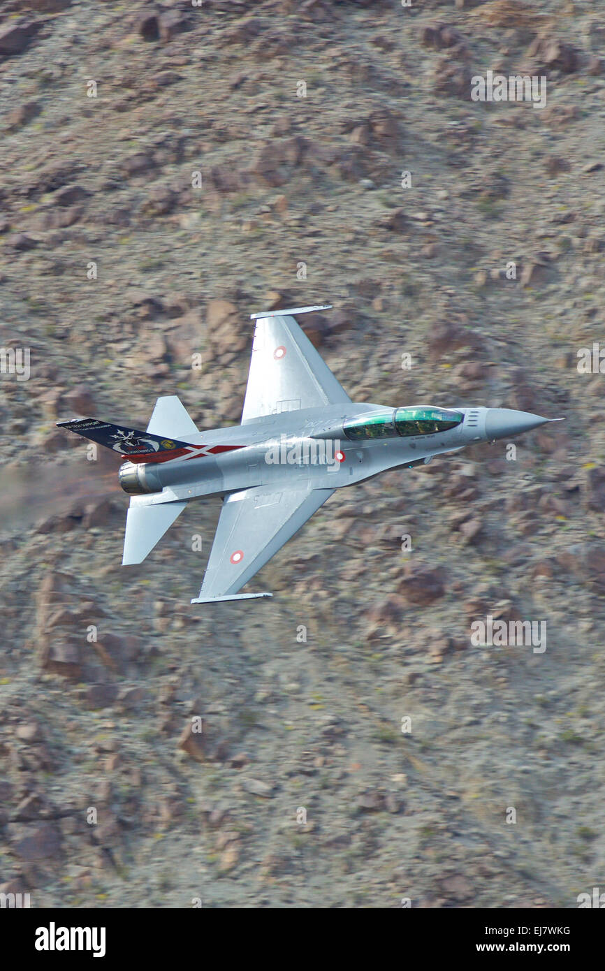 Vicino la foto di un Royal Air Force danese (Flyvevåbnet) F-16 jet fighter, Afterburner acceso, volare lungo una vallata desertica. Foto Stock