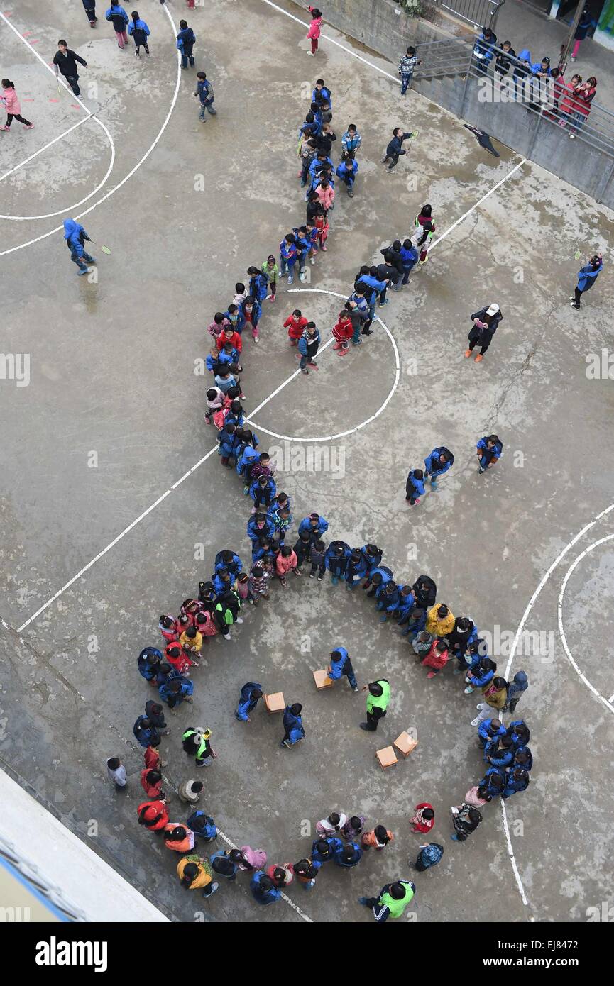 (150323) -- BANSHENG, 23 marzo 2015 (Xinhua) -- i bambini giocare con i Volontari sul loro nuovo parco giochi a Nongyong scuola primaria in Bansheng County, a sud della Cina di Guangxi Zhuang Regione autonoma, Gennaio 6, 2015. Nongyong la scuola primaria è stato costruito nel 1964. È situato nella contea di Bansheng, una zona rurale di topografia carsica in Guangxi. La sua iniziale edificio scolastico consiste di 12 case a un solo piano. Negli anni novanta, un edificio a due piani edificio di insegnamento e ruvide dormitorio sono state costruite. Ci sono circa 250 studenti provenienti da tutti i 22 villaggi di Nongyong. Ogni lunedì, la maggior parte di essi hanno a camminare sulle colline su Foto Stock