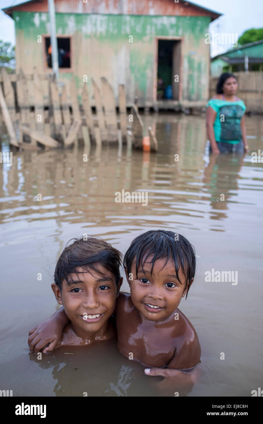 2015 Inondazioni in Amazzonia brasiliana - i bambini giocano nelle acque sporche di acri di fiume nel quartiere di Taquari, Rio Branco città, Acre. Le inondazioni sono state che colpisce migliaia di persone in stato di Acre, nel nord del Brasile, dal 23 febbraio 2015, quando alcuni dei suoi fiumi, in particolare il fiume acri, in overflow. Ulteriori pioggia pesante ha costretto i livelli del fiume ancora maggiore, e il 03 marzo 2015 Brasile del governo federale ha dichiarato lo stato di emergenza in stato di acri, dove alluvioni corrente situazione è stata descritta come la peggiore in 132 anni. Foto Stock