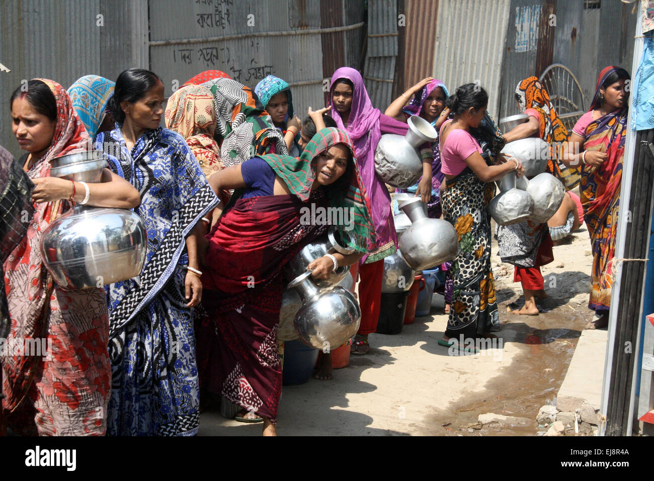 Dacca in Bangladesh. 23 Mar, 2015. I residenti del Bangladesh coda per raccogliere acqua da una cisterna a Dhaka il 23 marzo 2015 in una zona che sta vivendo una grave crisi di acqua per più di un mese. Tagli di potenza sono causa di gravi carenze idriche a Dhaka. Credito: Mamunur Rashid/Alamy Live News Foto Stock