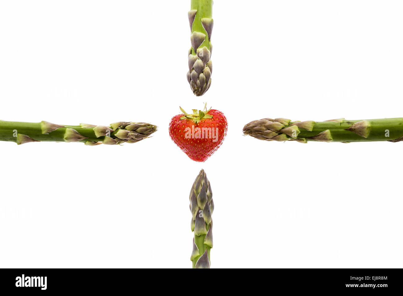 Quattro punte di asparagi e una fragola Foto Stock