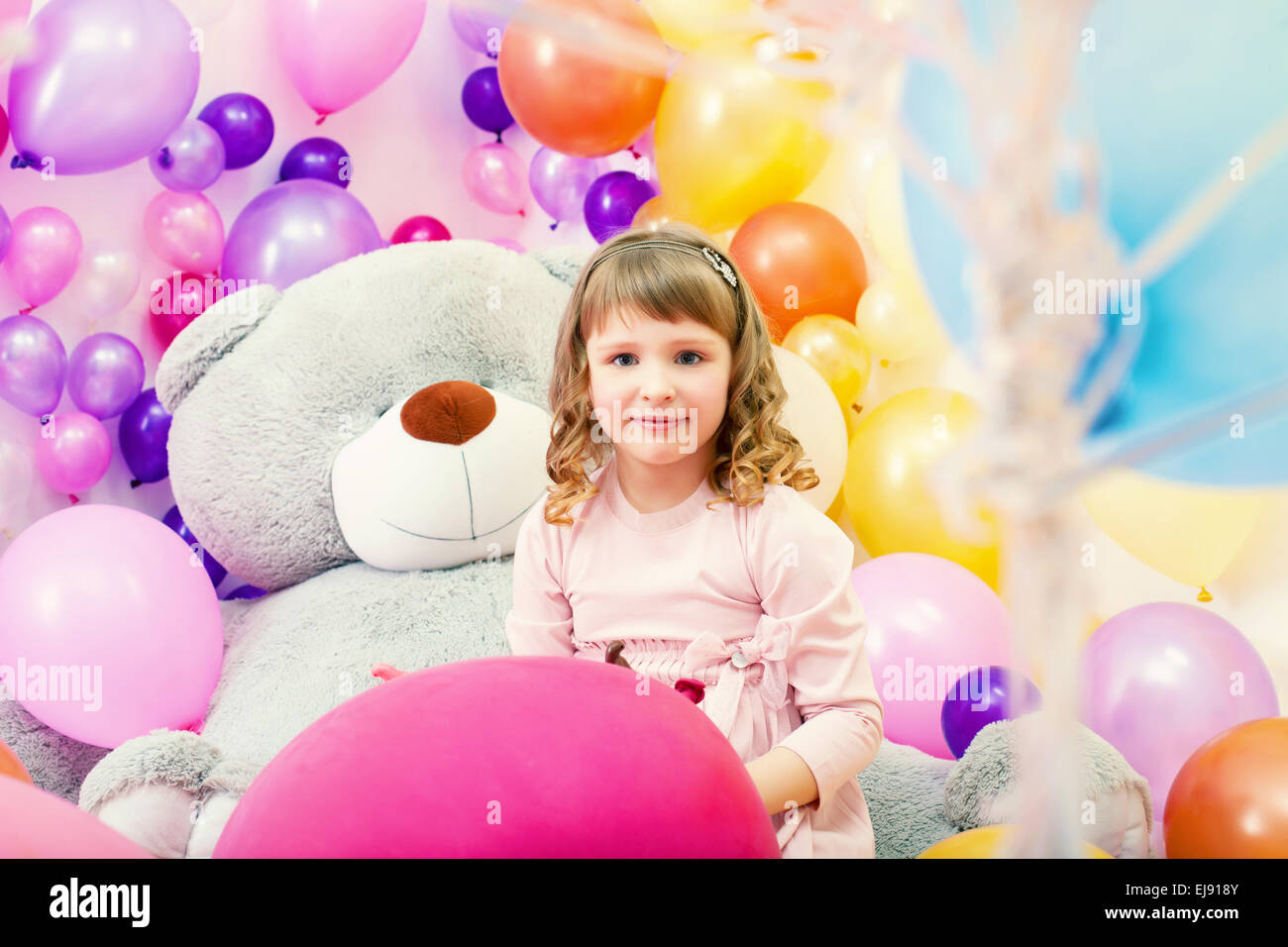 Sorridente bambina in posa nella sala giochi Foto Stock