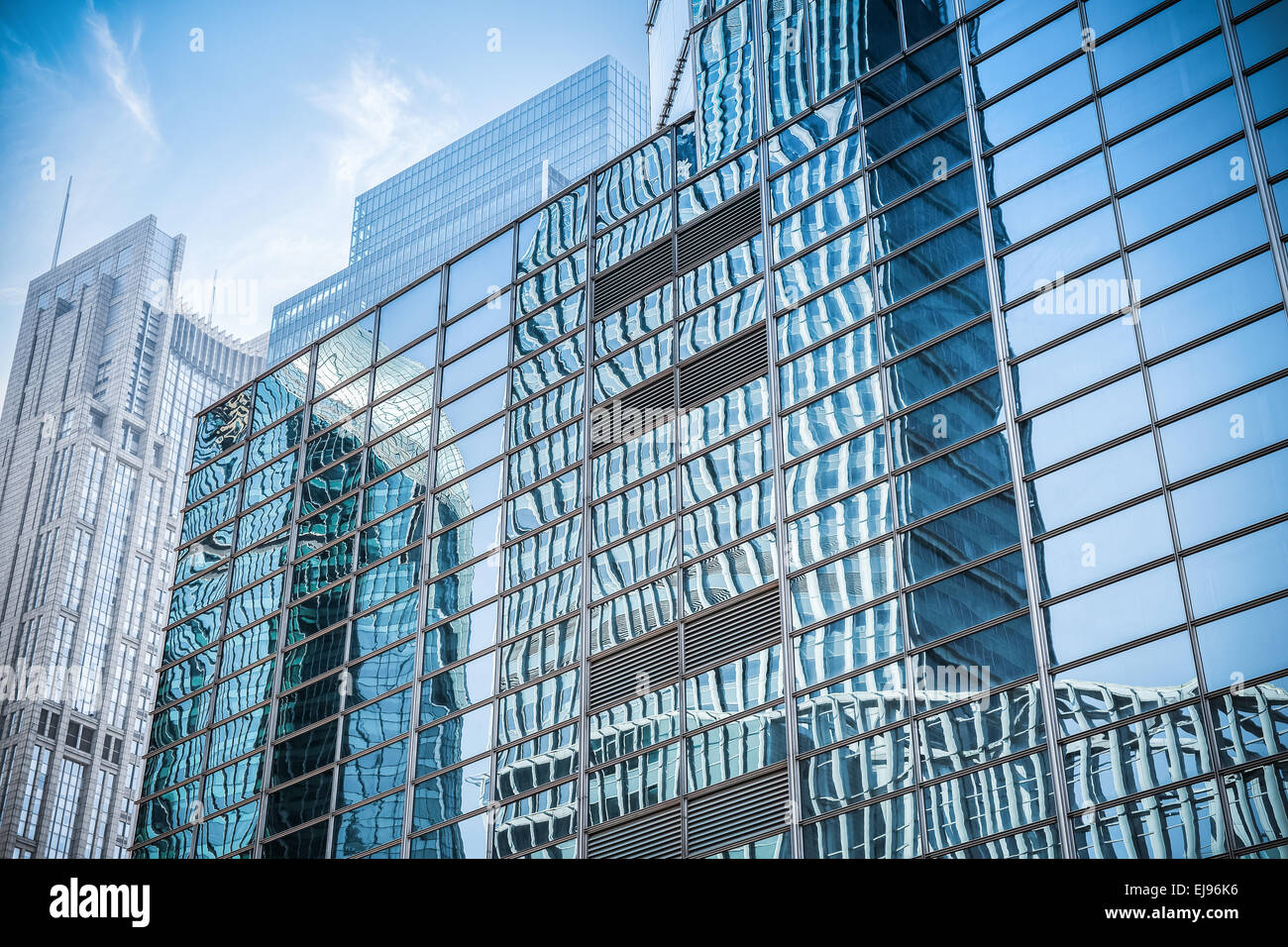La parete di vetro in un edificio moderno di grattacieli Foto Stock