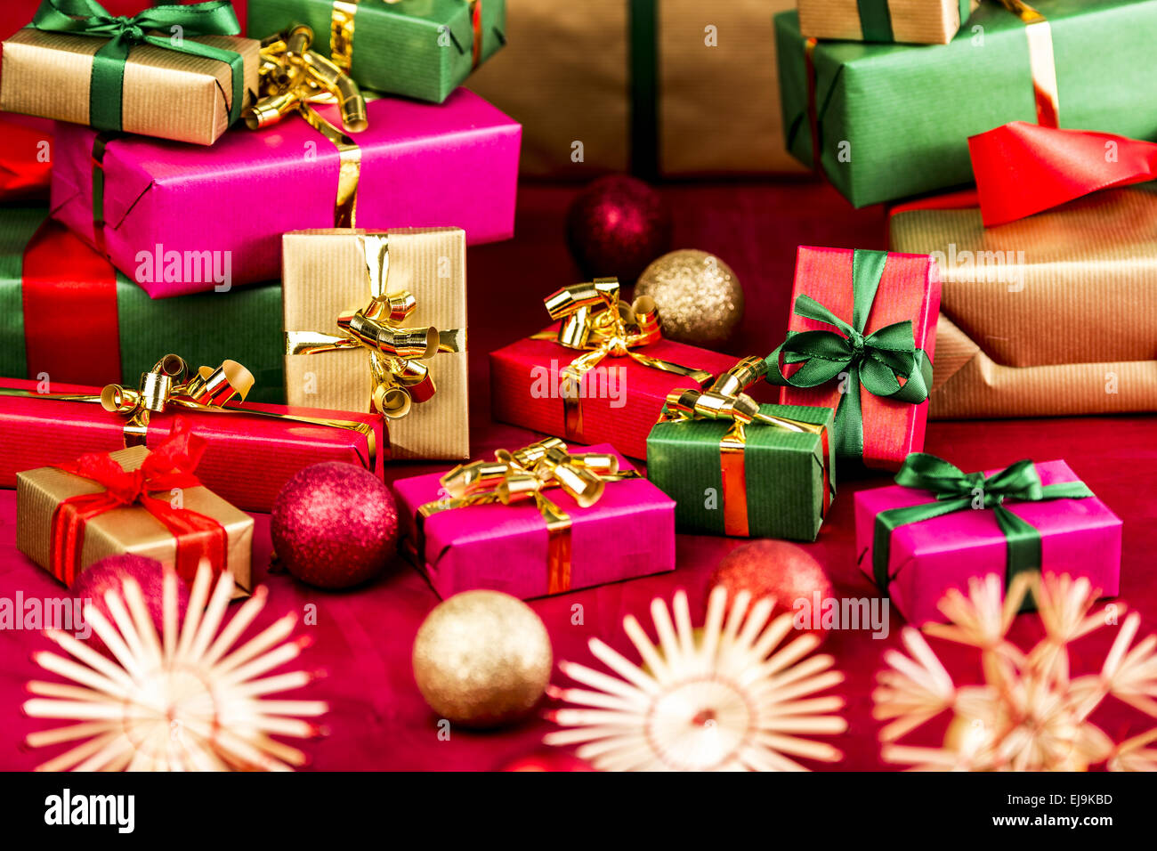 Numerosi regali di Natale disposti su un panno rosso Foto Stock