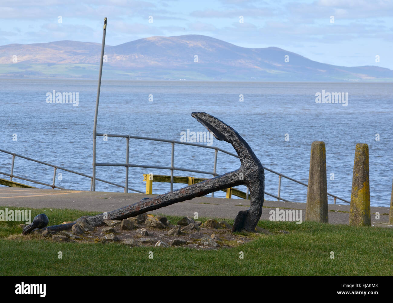 Arrugginimento anchor accanto alla stazione di salvataggio in Silloth, Cumbria, Inghilterra. Le colline del sud Galloway a distanza Foto Stock