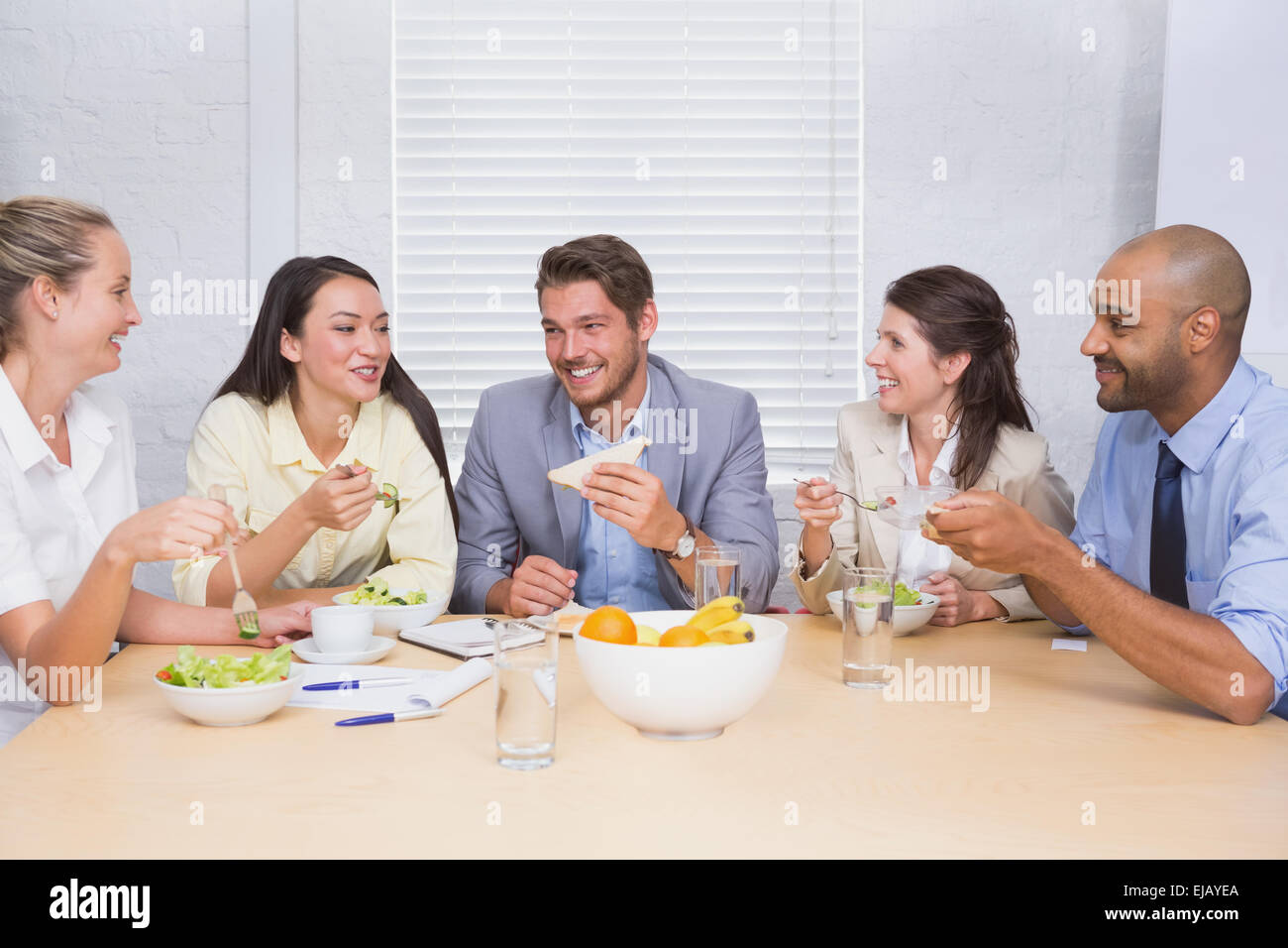 I lavoratori di ridere mentre godendo la pausa pranzo Foto Stock