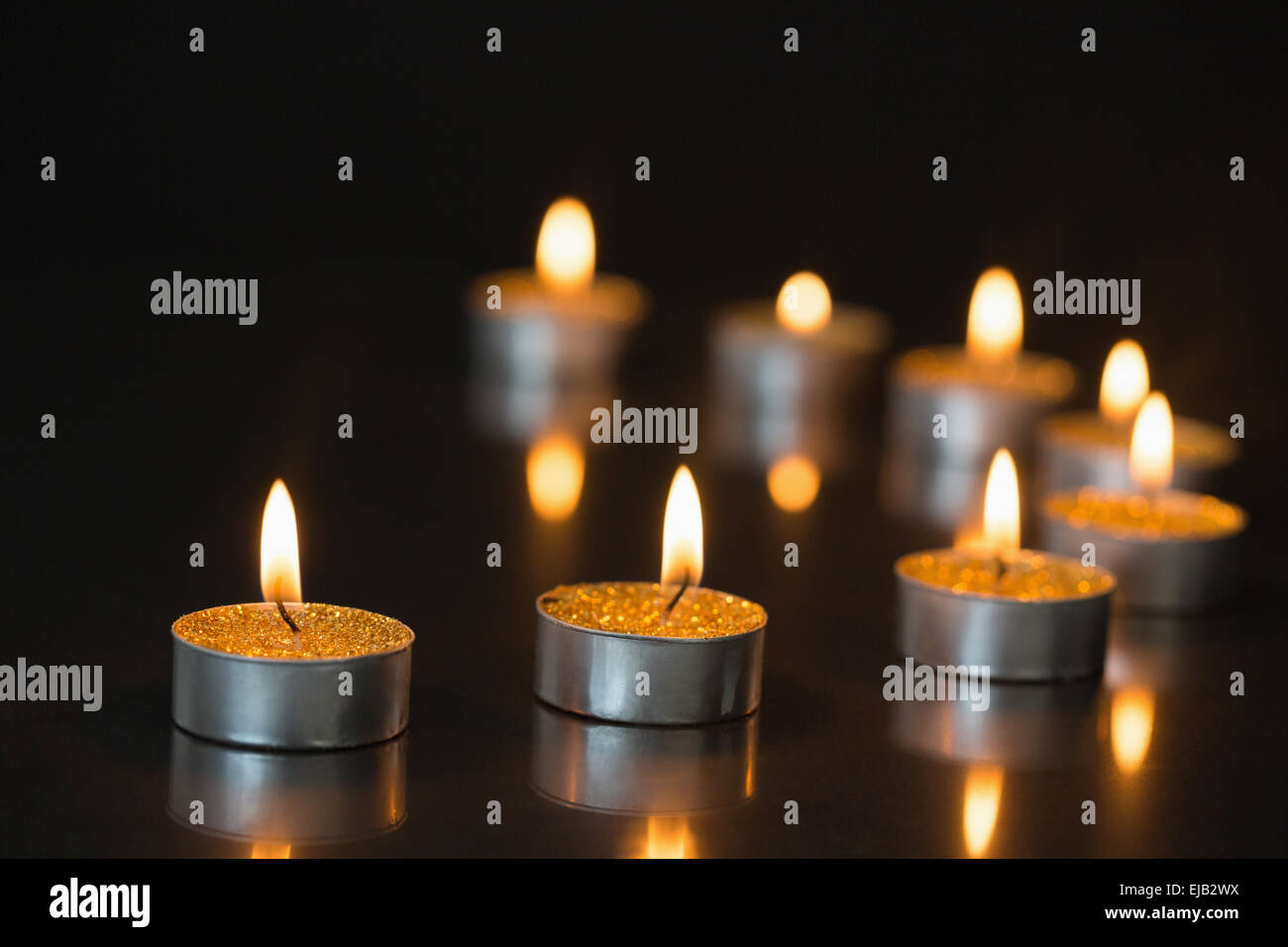 Otto piccole candele accese Foto Stock