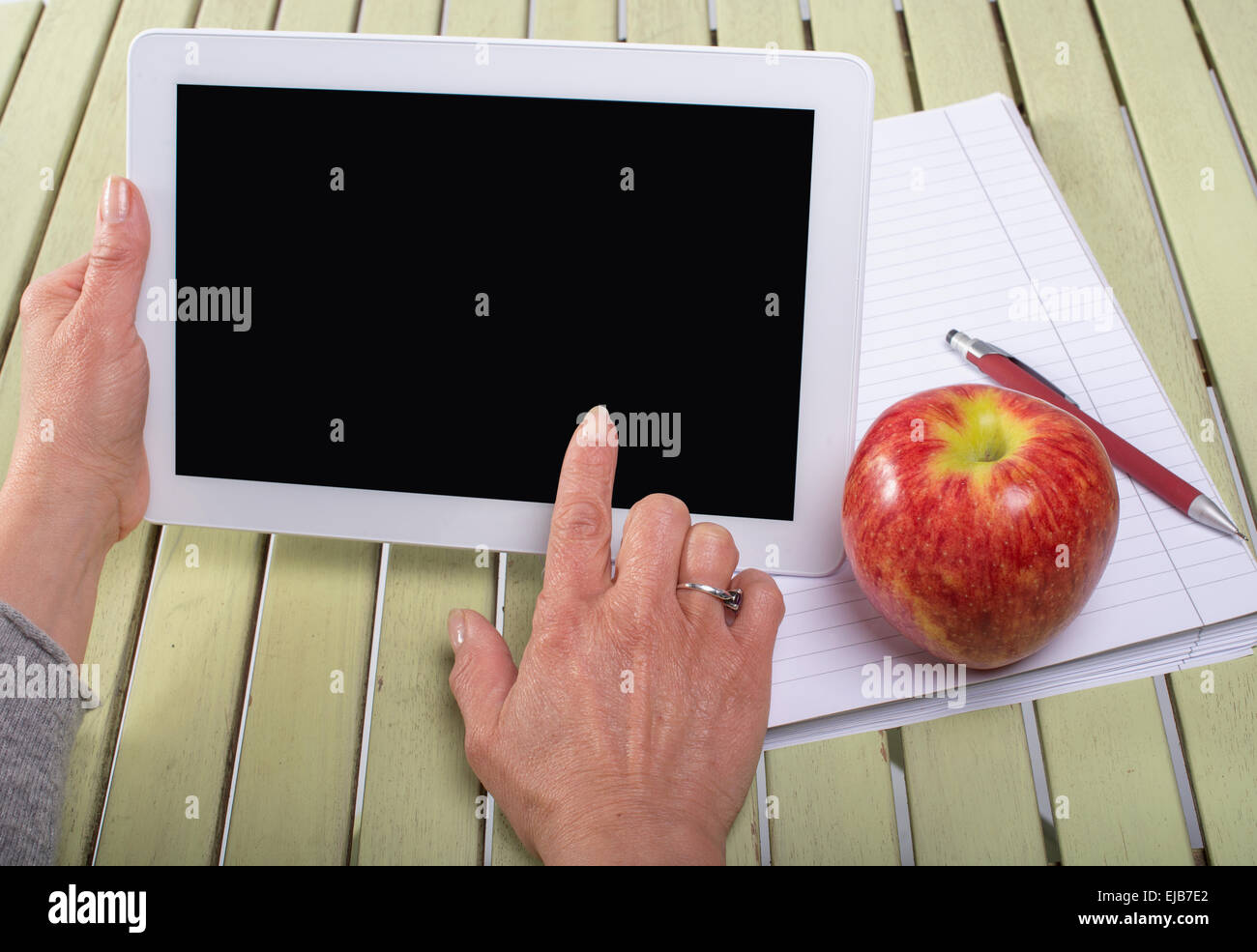 Donna che mantiene un computer tablet con un Apple Foto Stock