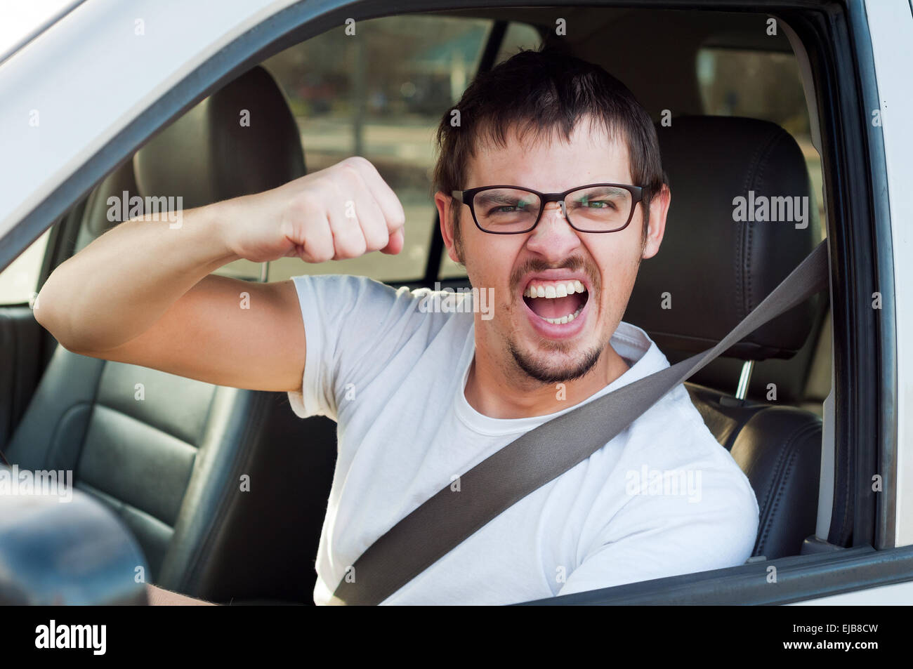 Maschio bianco arrabbiato driver è che mostra il pugno e mad face Foto Stock