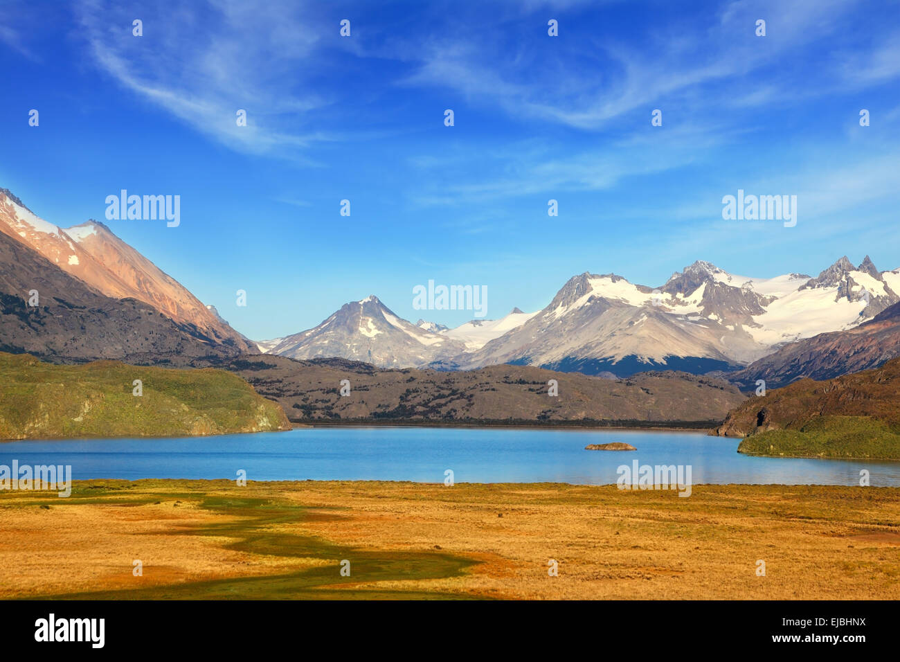Un lago blu e montagne innevate Foto Stock