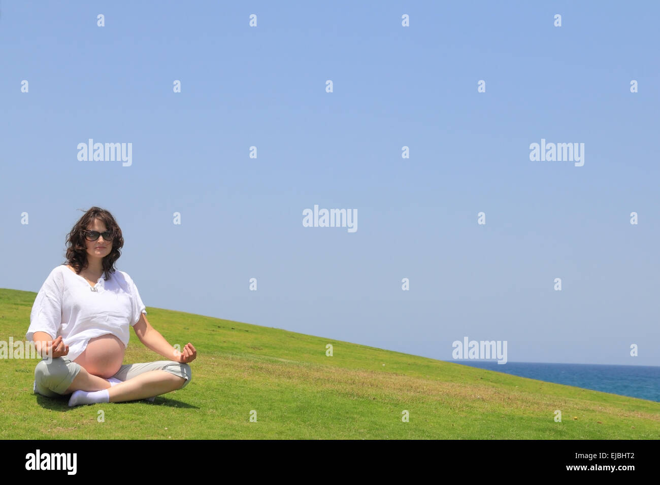 Felice giovane donna incinta fare yoga Foto Stock