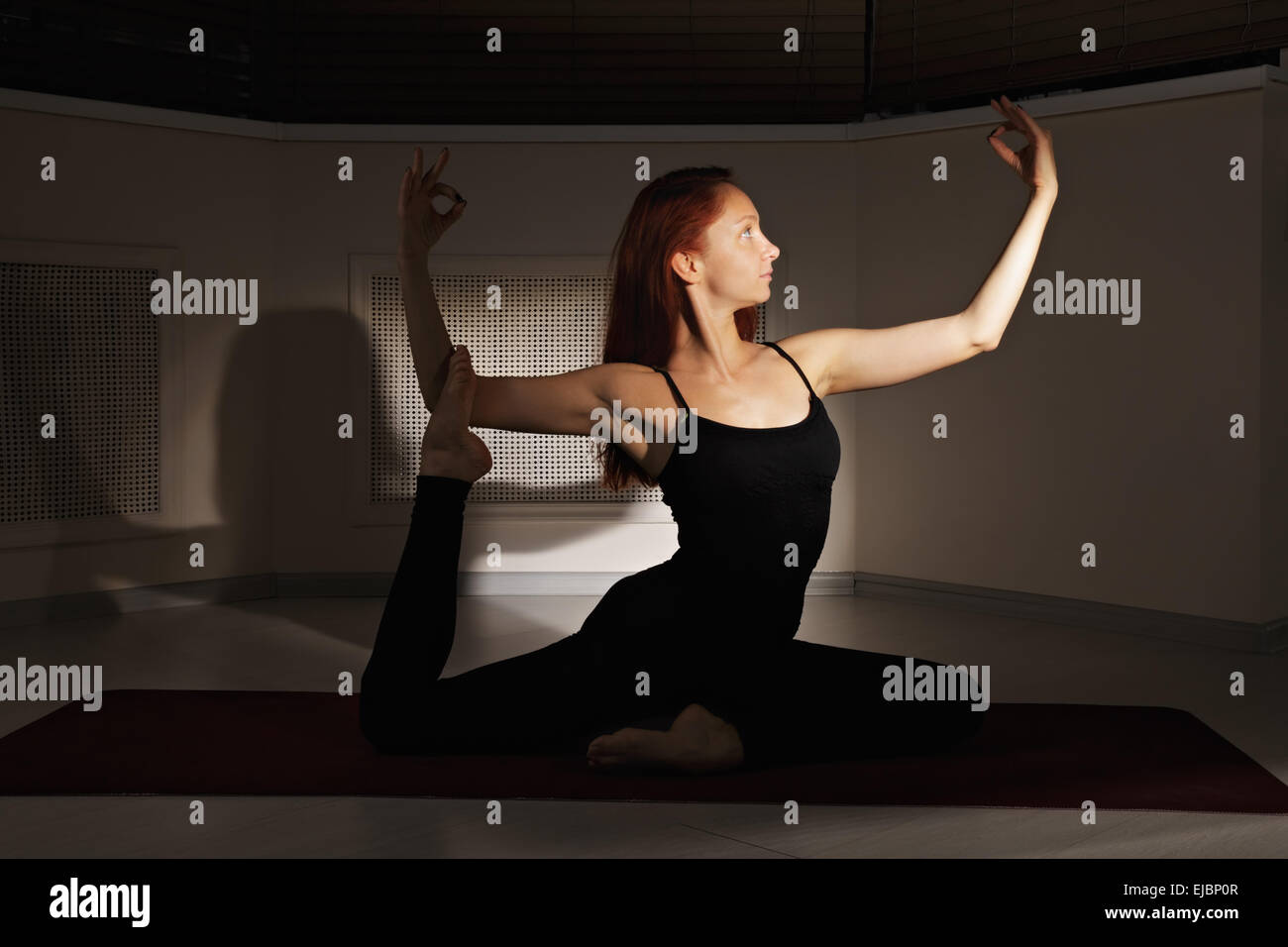 Redhead donna esercizio di hatha yoga Foto Stock