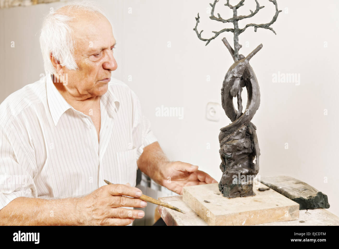 Scultore guardando il suo lavoro Foto Stock