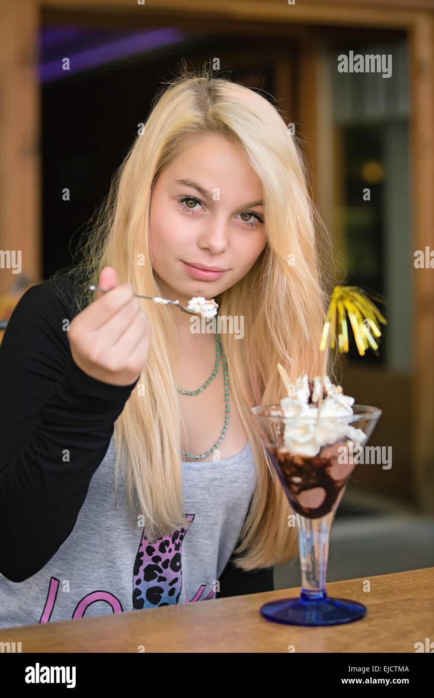 Giovane ragazza carina di mangiare il gelato al cioccolato Foto Stock