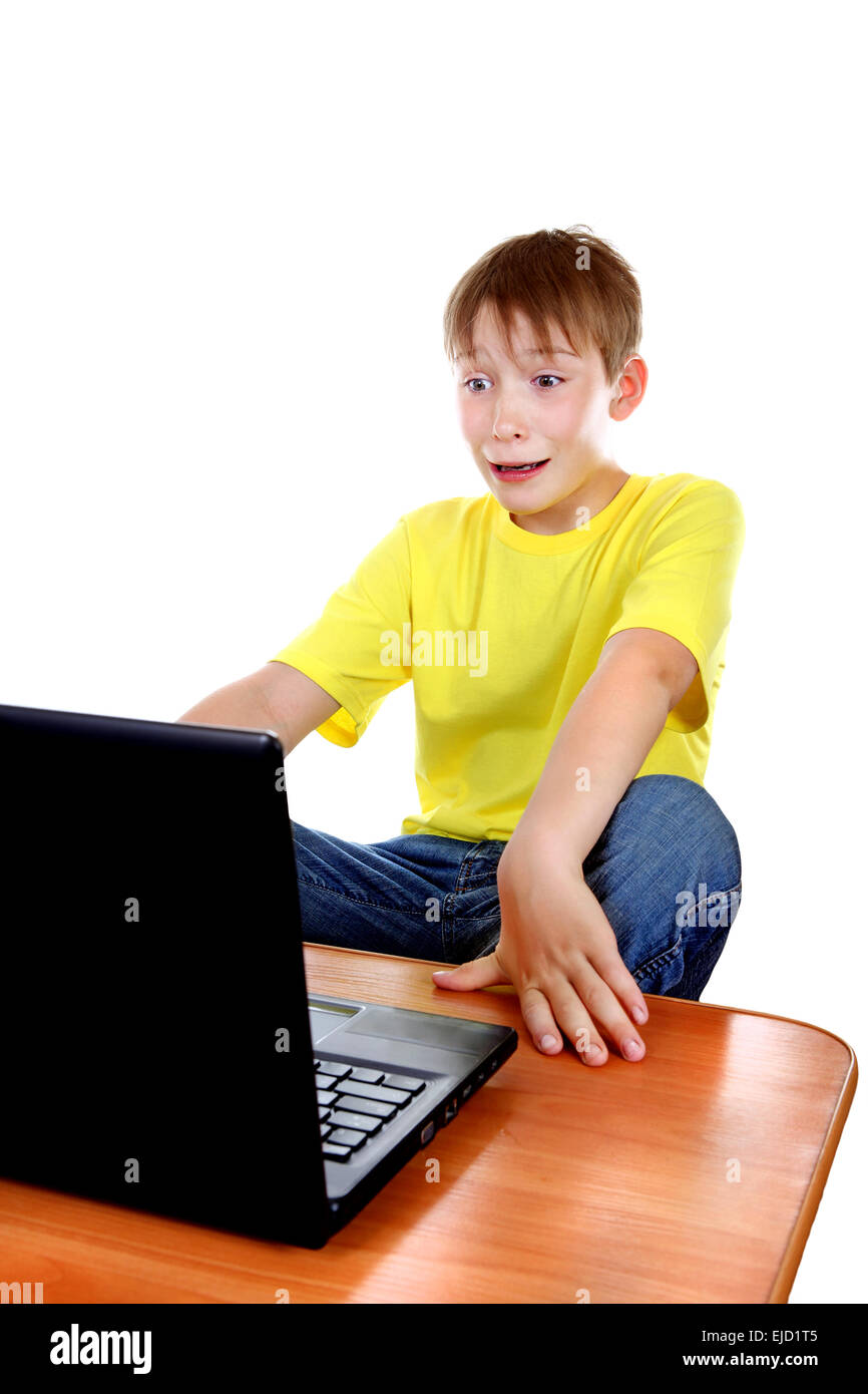Spaventata Kid con il computer portatile Foto Stock