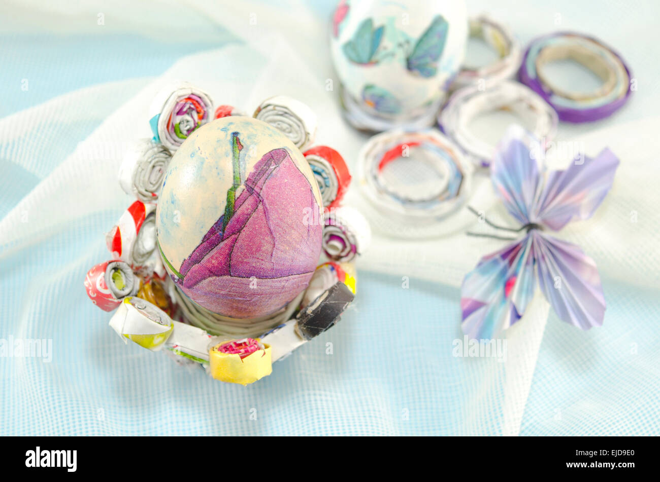 Fatte a mano decoupage uovo di Pasqua su una carta a mano decorata con una farfalla di carta Foto Stock