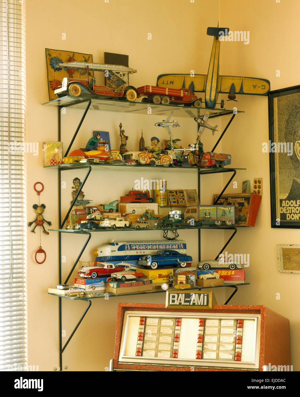 Collezione di giocattoli d'epoca sui ripiani in vetro degli anni novanta in studio con jukebox Foto Stock