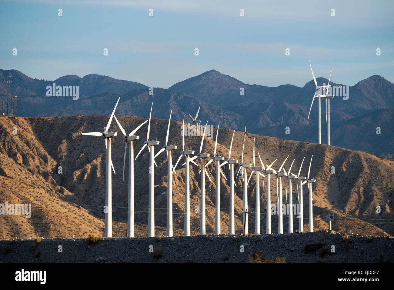 Wind Turbine di potenza nel paesaggio. Un gran numero di poteri di turbina su una pianura contro uno sfondo montano. Foto Stock