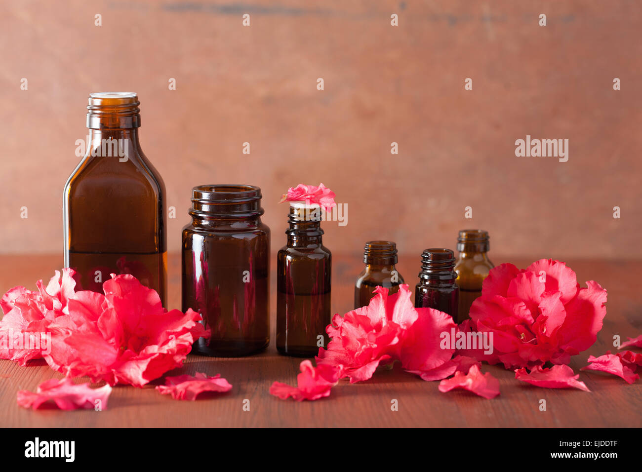 Olio essenziale di fiori di azalea su sfondo rustico Foto Stock