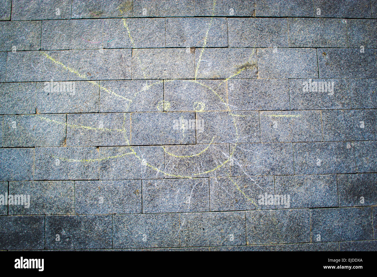 Disegnata a mano giallo sole con gesso di colore giallo su grigio piastrelle per pavimento Foto Stock