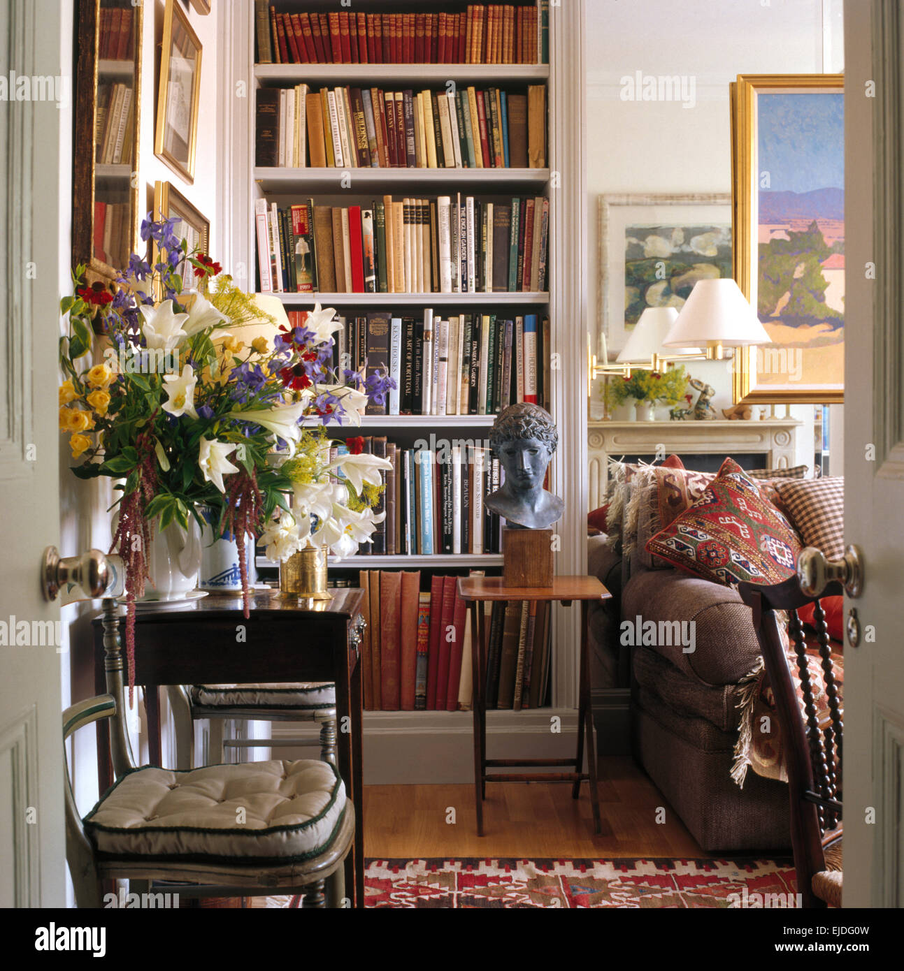 Estate floreali sul tavolino in townhouse confortevole salotto con dotati di librerie Foto Stock