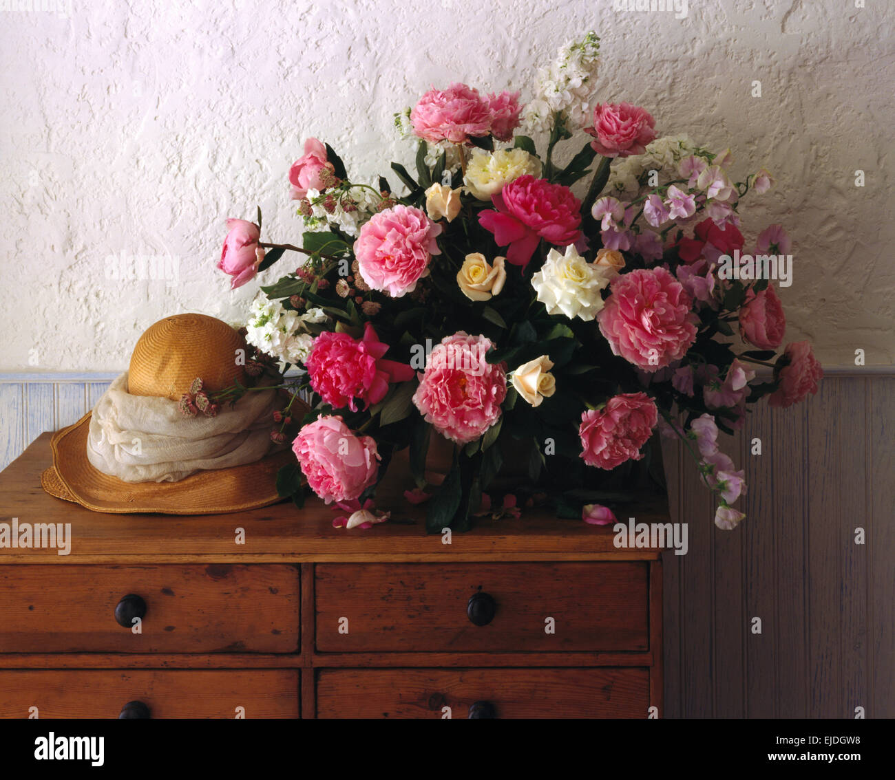 Still-Life di rosa e rose bianche in allestimento floreale con un vintage cappello di paglia Foto Stock