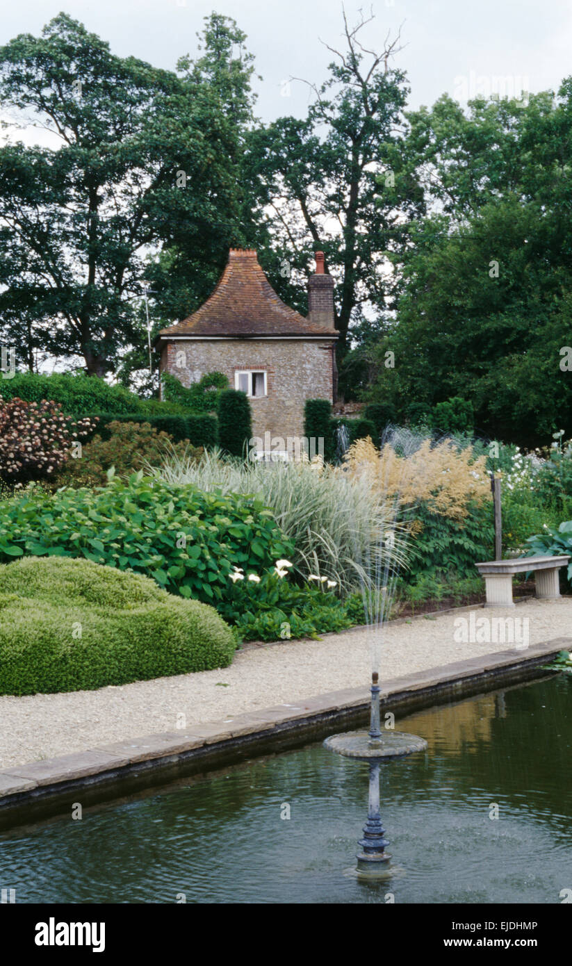 Piscina con piccola fontana nel paese grande giardino in estate con alte erbe e crema aruncus Foto Stock Piscina con piccola fontana nel paese grande giardino in estate con alte erbe e crema aruncus Foto Stock